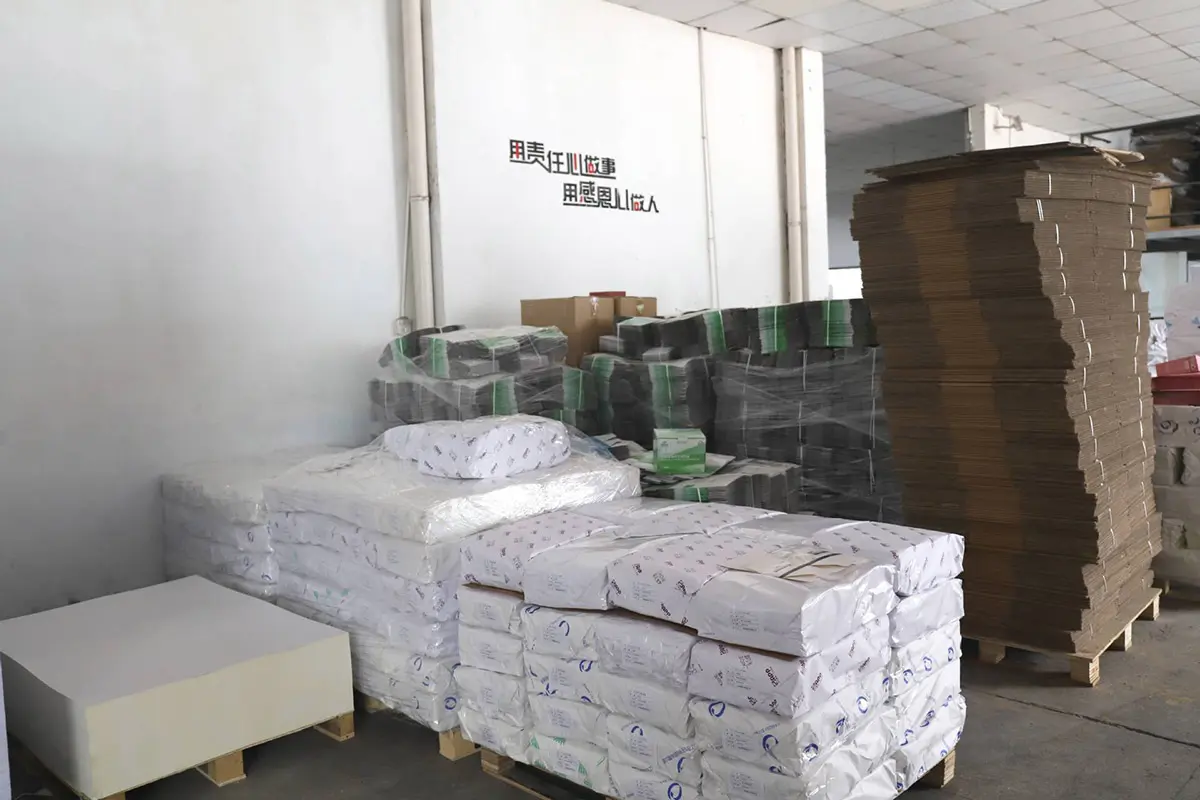 Finished packaging boxes stacked beside the production area
