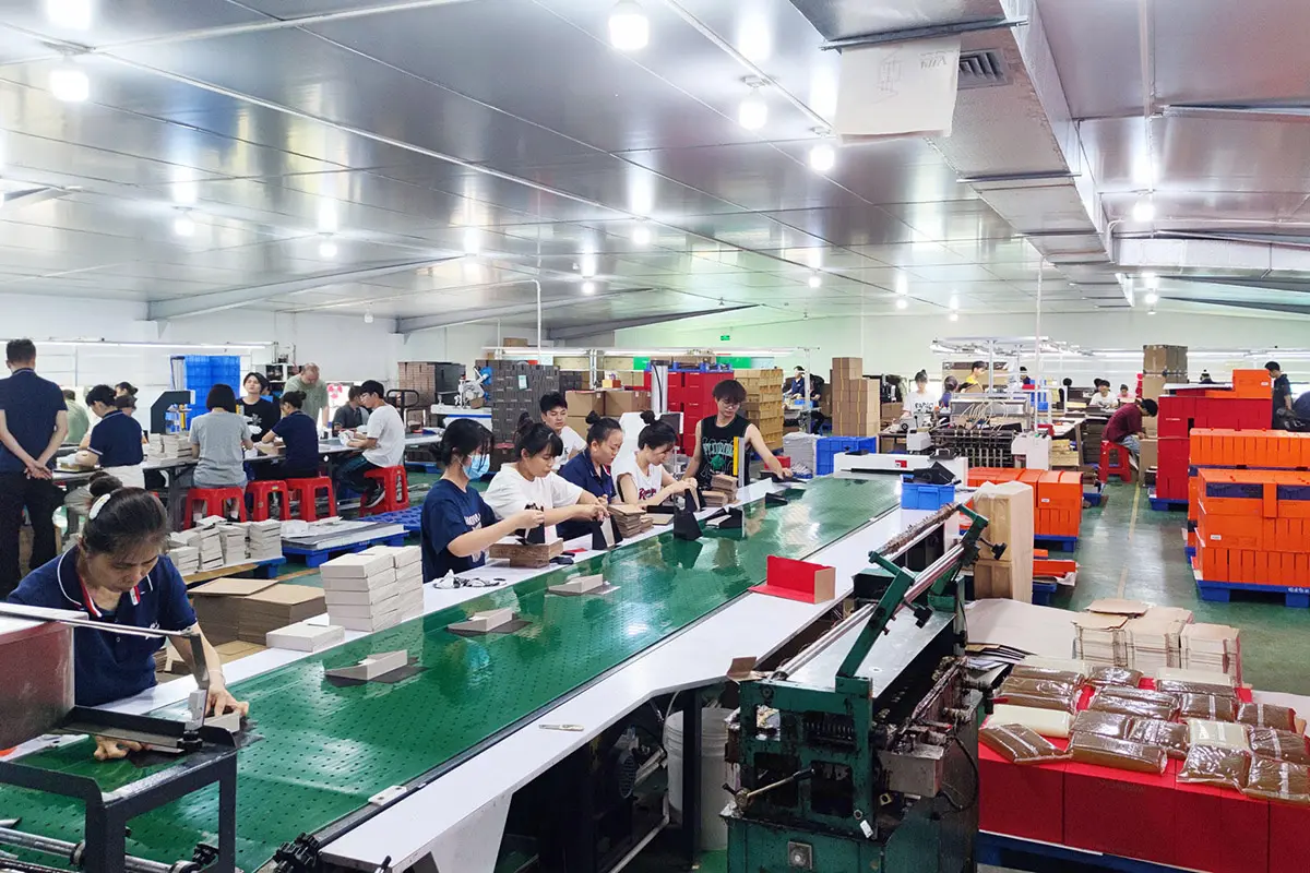 Workers assembling packaging components along the production line