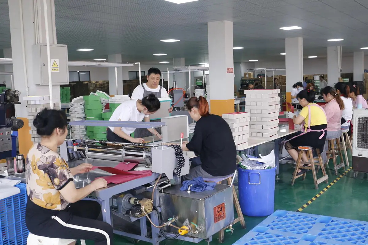 Manual finishing area with workers at long tables
