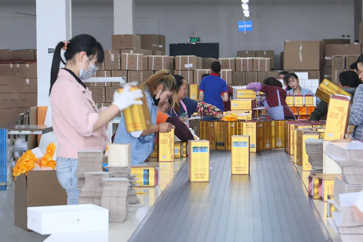 Workers assembling and checking custom packaging boxes by hand