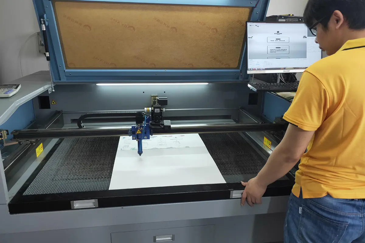 Worker operating real paperboard die-cutting equipment