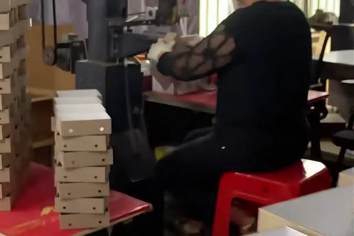 Worker hand-assembling a real custom gift box sample